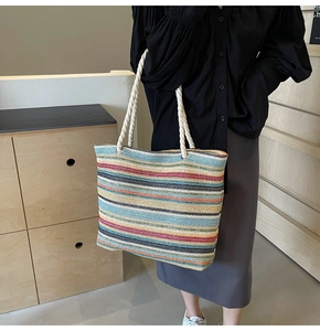 Gros plan d'un sac cabas tissé à rayures colorées avec des poignées en corde blanche