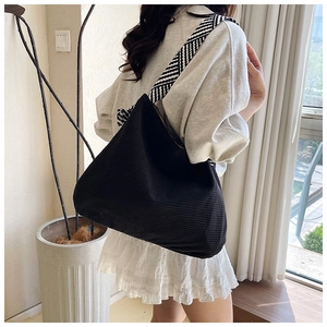 Detail of black corduroy tote bag with black and white geometric patterned strap