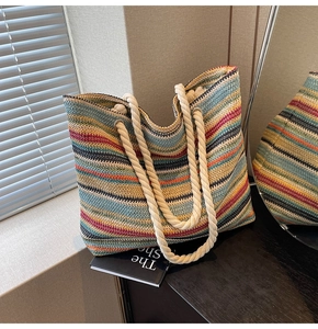 Détail d'un sac cabas tissé à rayures colorées avec poignées en corde et œillets en métal