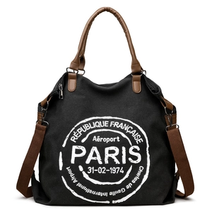 Large black canvas tote bag with brown leather straps and white Paris airport print