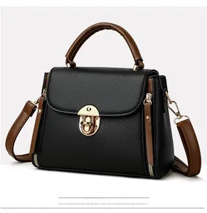Detailed view of the black lychee pattern leather handbag with brown strap and gold buckle