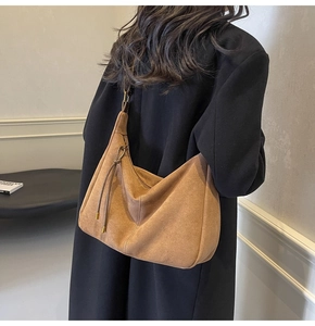 Detail of suede hobo bag with decorative drawstring and premium gold-tone hardware
