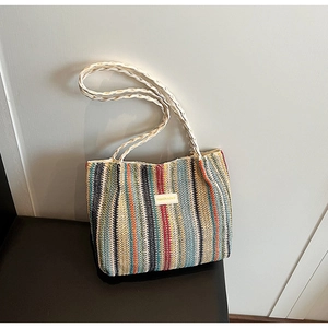 Close-up of woven tote bag featuring colorful vertical stripes and fashion brand label
