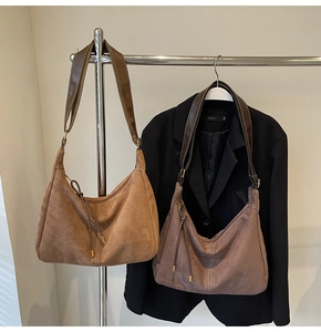 Detail of vintage suede hobo bags in camel and taupe with stitching and tassels