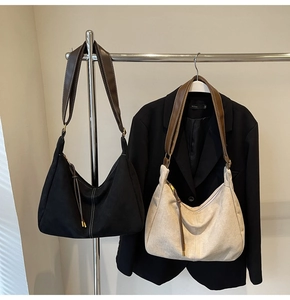 Detail of vintage suede hobo bags in black and beige with brown leather straps