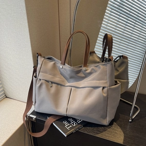 Borsa tote minimalista in nylon grigio chiaro con manici marroni e design multi-tasca