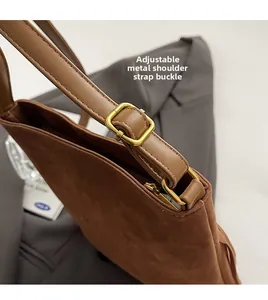 Close-up of adjustable gold-tone buckle on brown suede embroidered shoulder bag strap