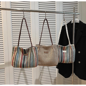 Detail of woven tote bags with striped patterns and fashion logo label in office setting