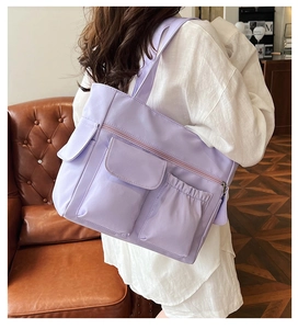 Detail of lavender multi-pocket tote bag showing the nylon fabric and functional storage