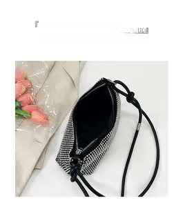 Macro view of the rhinestone crossbody bag showing spacious interior and black lining