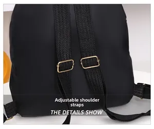 Détail d'un sac à dos noir avec bretelles réglables et boucles en métal doré