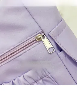 Close-up of smooth metal zipper on purple fabric shoulder bag with detailed stitching