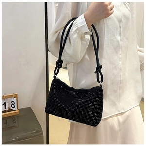 Detail of black rhinestone shoulder bag featuring unique knotted strap and shiny crystals