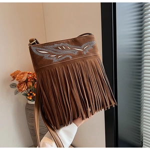 Detail of coffee brown crossbody bag featuring bohemian fringe and intricate embroidery