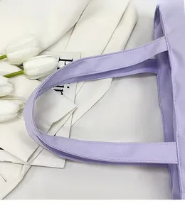 Close-up of comfortable reinforced handles and stitching on light purple canvas tote bag