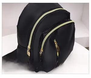 Vue détaillée des fermetures éclair dorées et du tissu en nylon noir haute densité