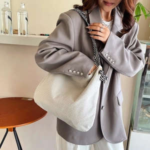 White corduroy tote bag with zebra print strap and knot detail shown on model