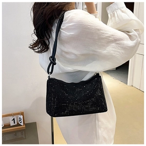 Detail of black rhinestone shoulder bag with a unique knotted leather strap design