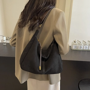 Vintage black suede dumpling bag with contrast stitching and adjustable wide shoulder strap