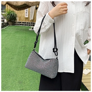 Close-up of sparkling rhinestone baguette bag featuring a knotted black PU strap