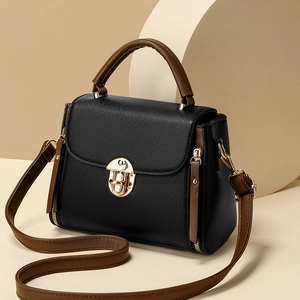 Chic black textured leather handbag with brown handles and a gold metal buckle