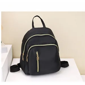 Vue détaillée du mini sac à dos en nylon noir avec fermetures éclair dorées et compartiments