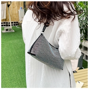 Detail of a sparkling rhinestone underarm bag with iridescent finish and black handle