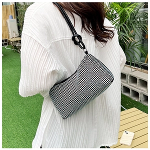 Fashionable black rhinestone shoulder bag shown on shoulder for sizing and fit reference