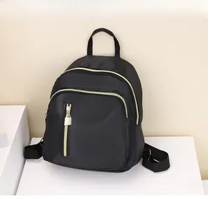 Détail du mini sac à dos noir avec fermetures dorées et tissu en nylon imperméable