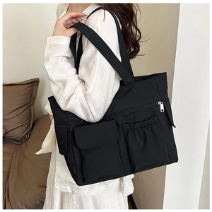 Side view of black nylon tote bag with functional pockets and secure metal zipper