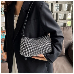 Close-up of sparkling silver rhinestones on a black baguette bag with slim shoulder strap