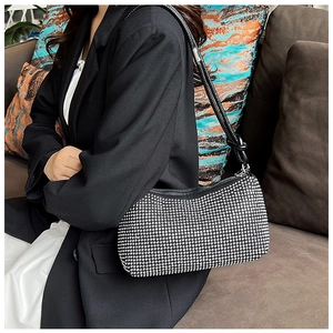Close-up of sparkling silver rhinestones on a stylish black shoulder bag