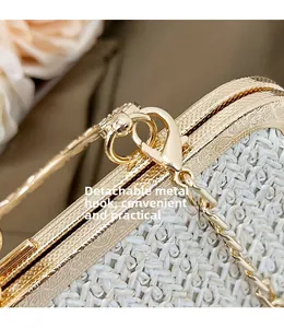 Close-up of golden embossed vintage clasp and detachable chain on straw woven bag