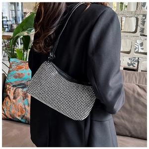 Detailed back view of a woman wearing the black rhinestone shoulder bag under the arm