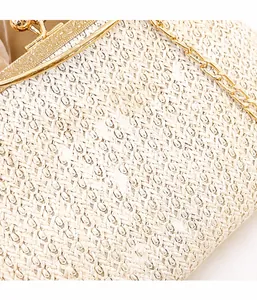 Detail of vintage carved gold frame and clasp on beige straw shell-shaped handbag