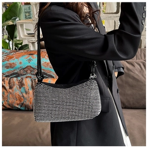 Detail of shimmering silver rhinestones on a black baguette bag with elegant leather strap