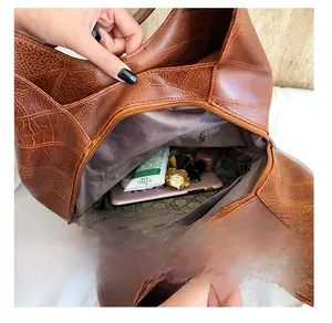 Close-up of brown vintage leather tote bag interior showing large capacity and zipper pocket