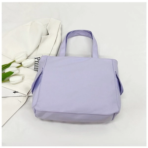 Detail of light purple minimalist tote bag with side flap pockets and sturdy top handles