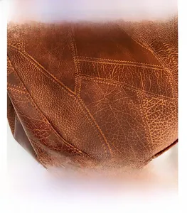 Macro shot showing high-quality stitching and texture of vintage brown leather shoulder bag