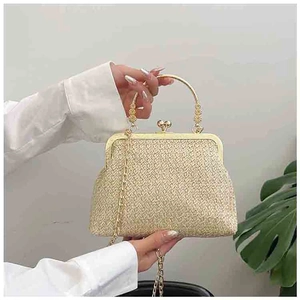 Detail of vintage gold woven clutch featuring a metallic heart-shaped clasp and chain strap