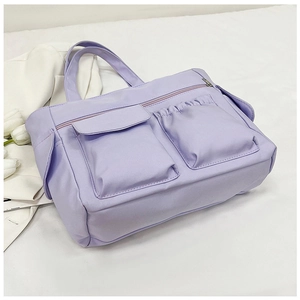 Detail view of a light purple multi-pocket nylon tote with metal zipper and soft fabric texture