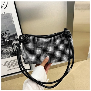 Detail of black rhinestone shoulder bag with silver crystals and leather strap