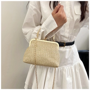 Close-up of beige woven straw bag with golden vintage clasp and metal chain handle