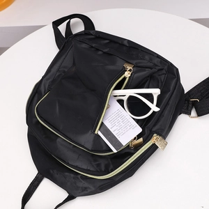 Sac à dos minimaliste en nylon noir avec fermeture éclair dorée pour usage quotidien