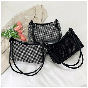 Detail of elegant rhinestone underarm bags in black and silver with knotted leather straps