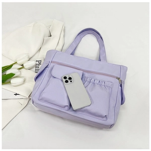 Detail view of purple nylon tote bag with multi-pocket storage and zip closure