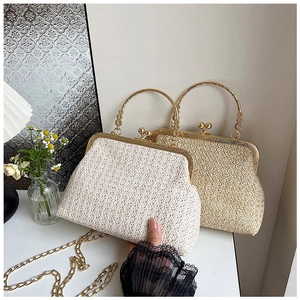 Detail of vintage straw woven bag with gold metal ring handle and chain shoulder strap