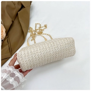 Detail of cream woven handbag showing V-pattern texture and elegant gold ring handles