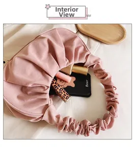 Detailweergave van de roze geplooide tas met ruimte voor cosmetica en smartphone