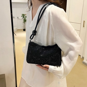 Chic black rhinestone shoulder bag with silver zipper shown on a model in a natural setting